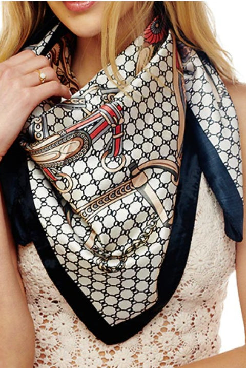 Woman wearing a patterned scarf with a horse and carriage design on a white background