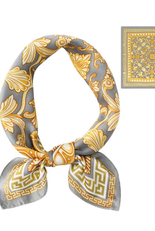 Gray and gold patterned scarf tied in a knot with a matching square on a white background
