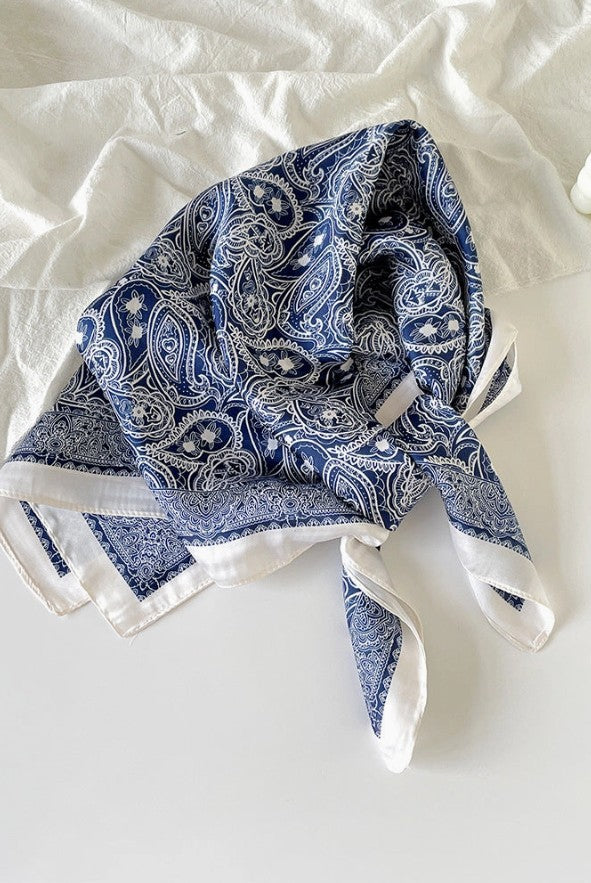 Blue paisley patterned scarf on a white surface