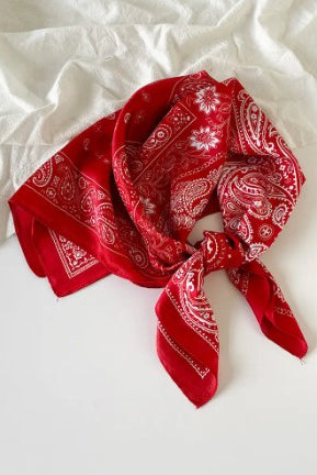 Red bandana with white patterns on a white fabric background