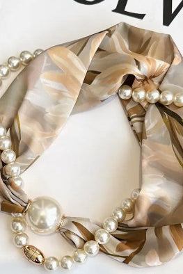 Decorative candle with pearls and gold ribbon on a white background