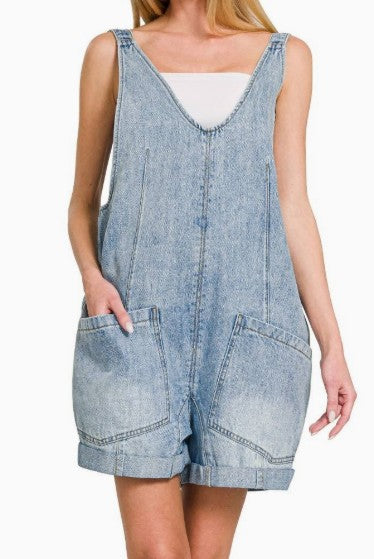 Denim overall dress worn by a person on a white background