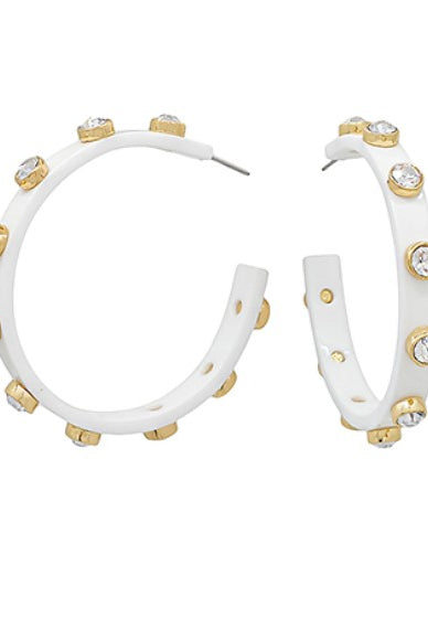 White hoop earrings with gold accents and clear stones on a white background