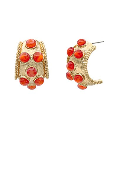 Gold hoop earrings with red gemstones on a white background