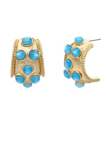 Gold hoop earrings with blue gemstones on a white background