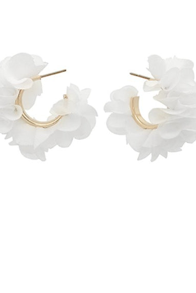 Pair of white ruffled hoop earrings on a white background