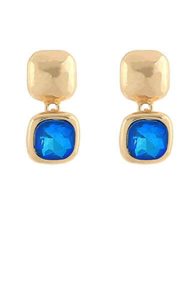Gold earrings with royal blue gemstones on a white background