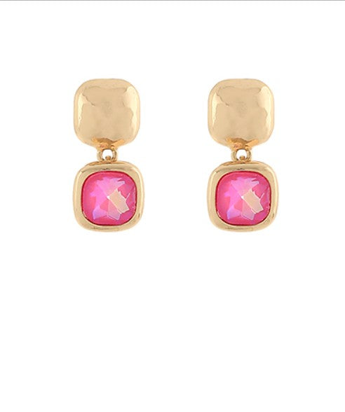 Gold earrings with pink gemstones on a white background