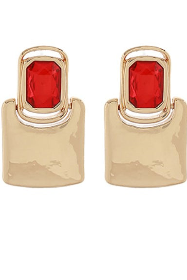 Gold earrings with red gemstones on a white background