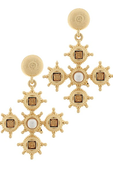 Gold earrings with star-like design on a white background