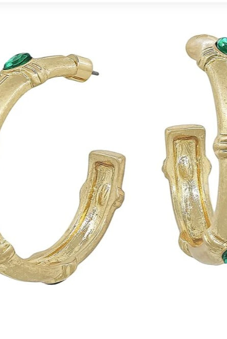 Gold hoop earrings with green gemstones on a white background
