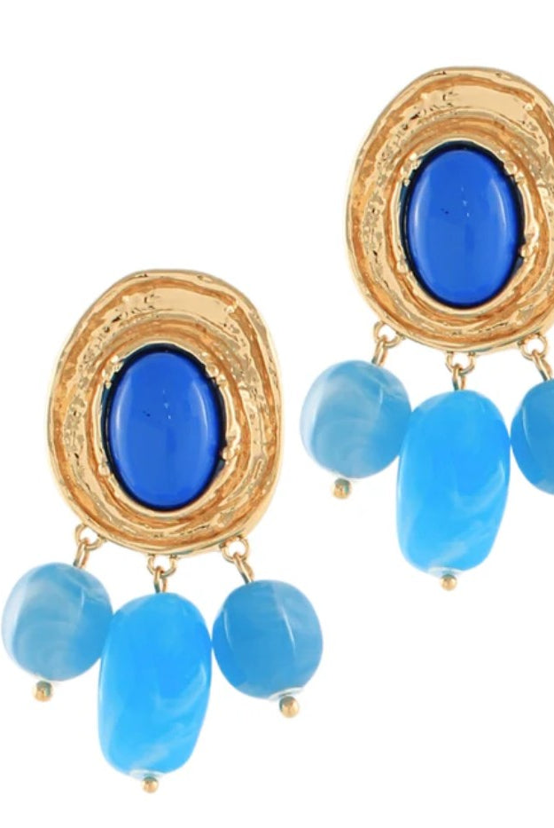 Gold-framed earrings with blue stones on a white background