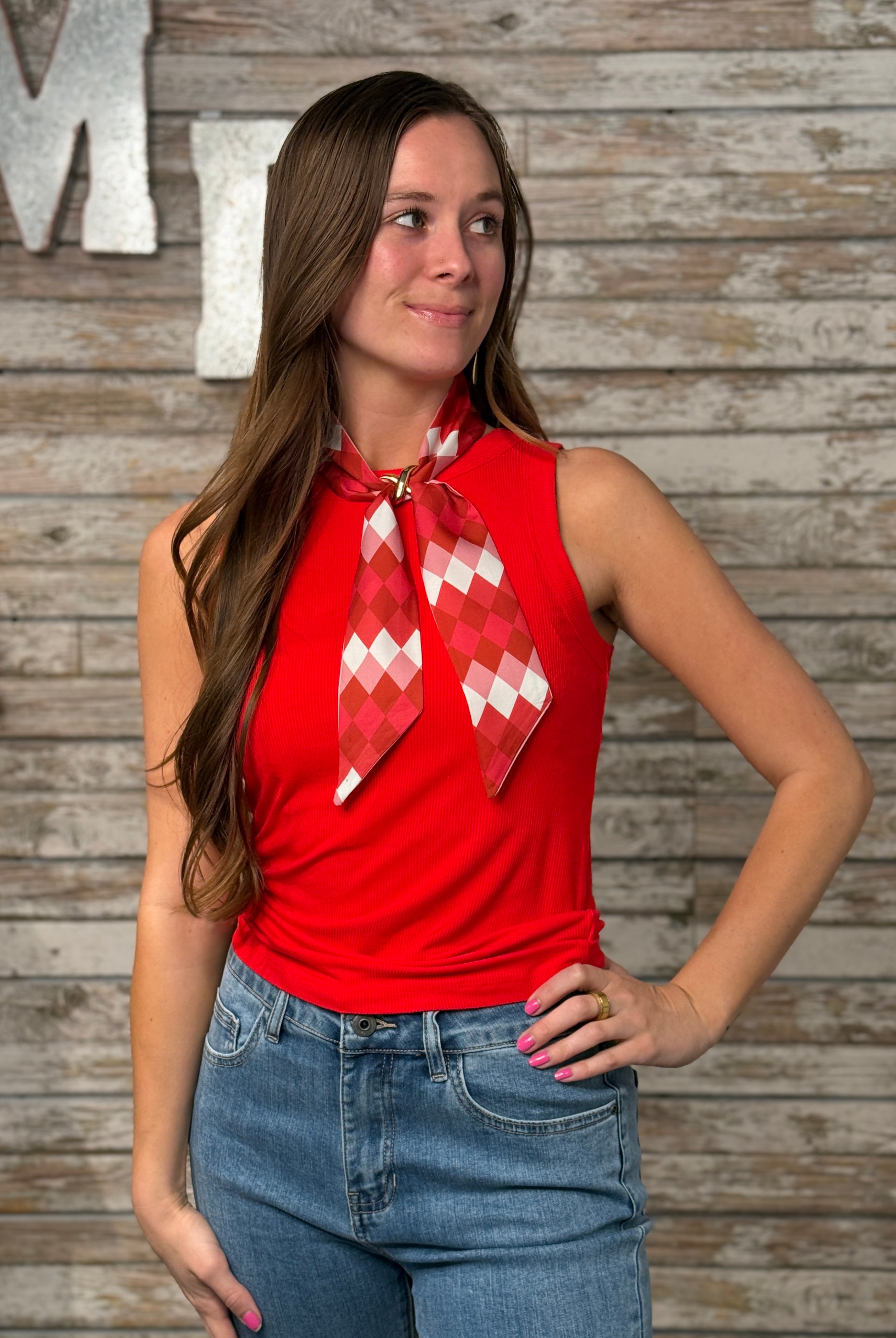 Woman wearing a fitted red ribbed sleeveless tank top with a high neckline and soft stretch fabric.