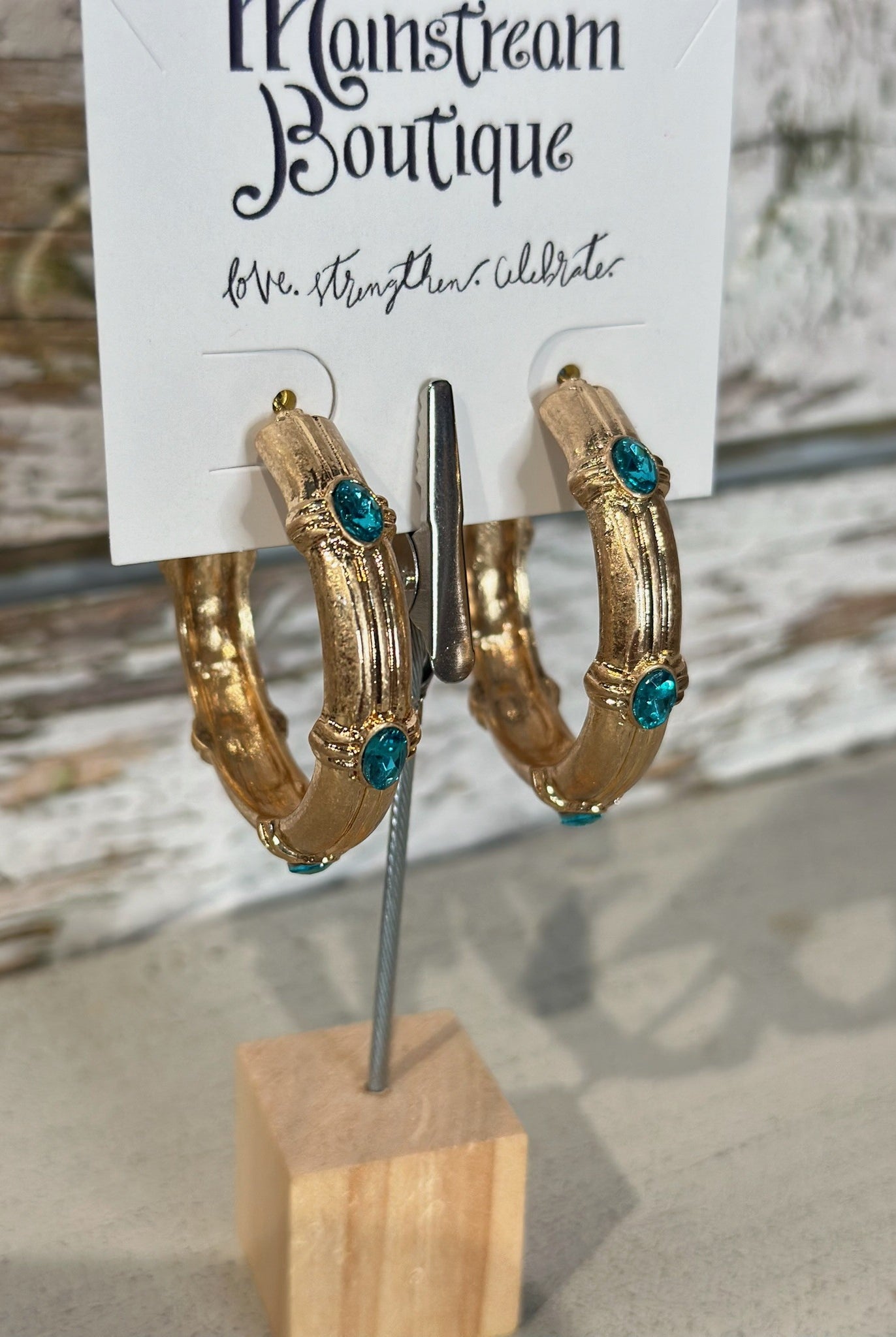 Gold hoop earrings with Aqua stones on a display card at Mainstream Boutique.