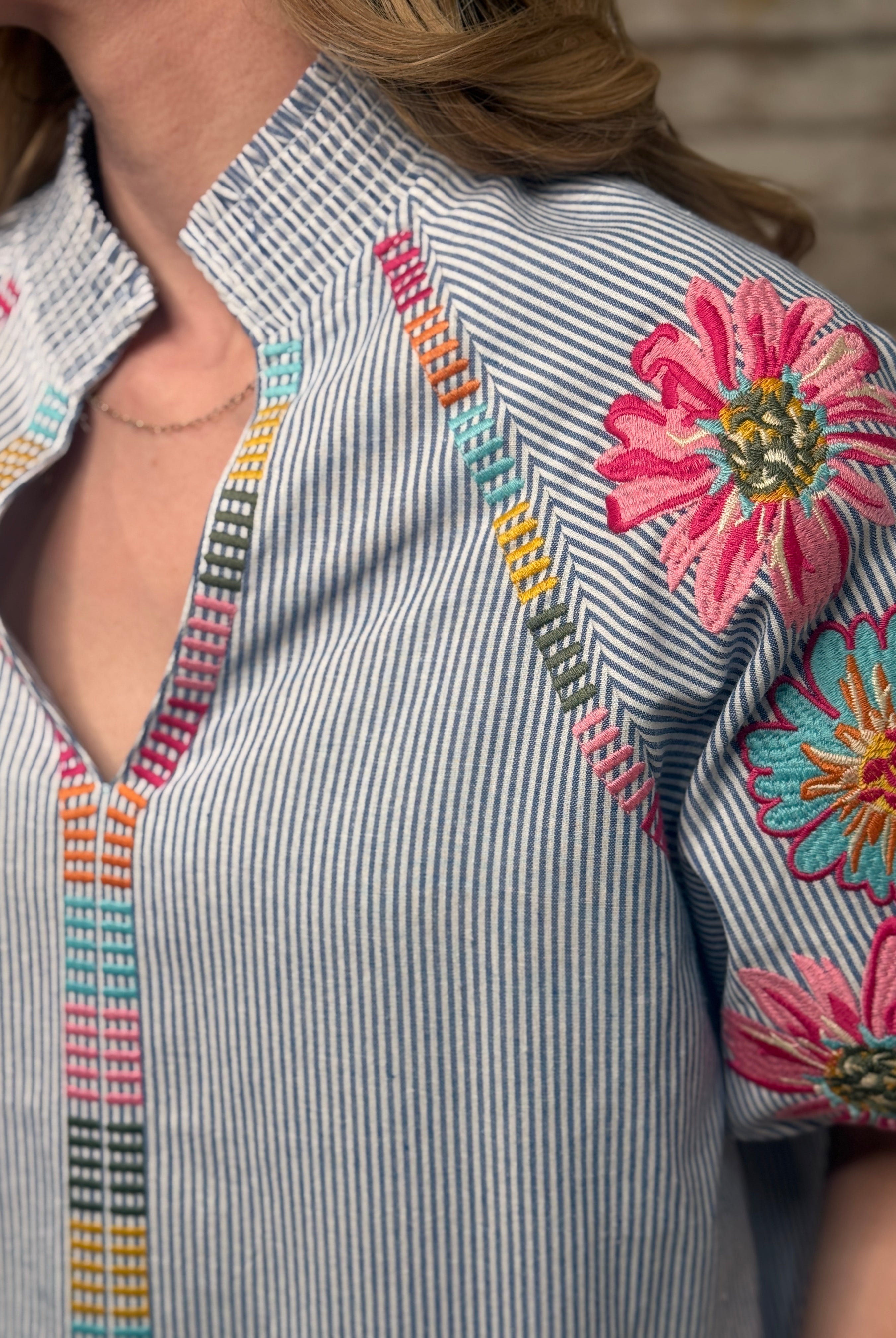 Close-up of a shirt with floral embroidery and colorful patterns.