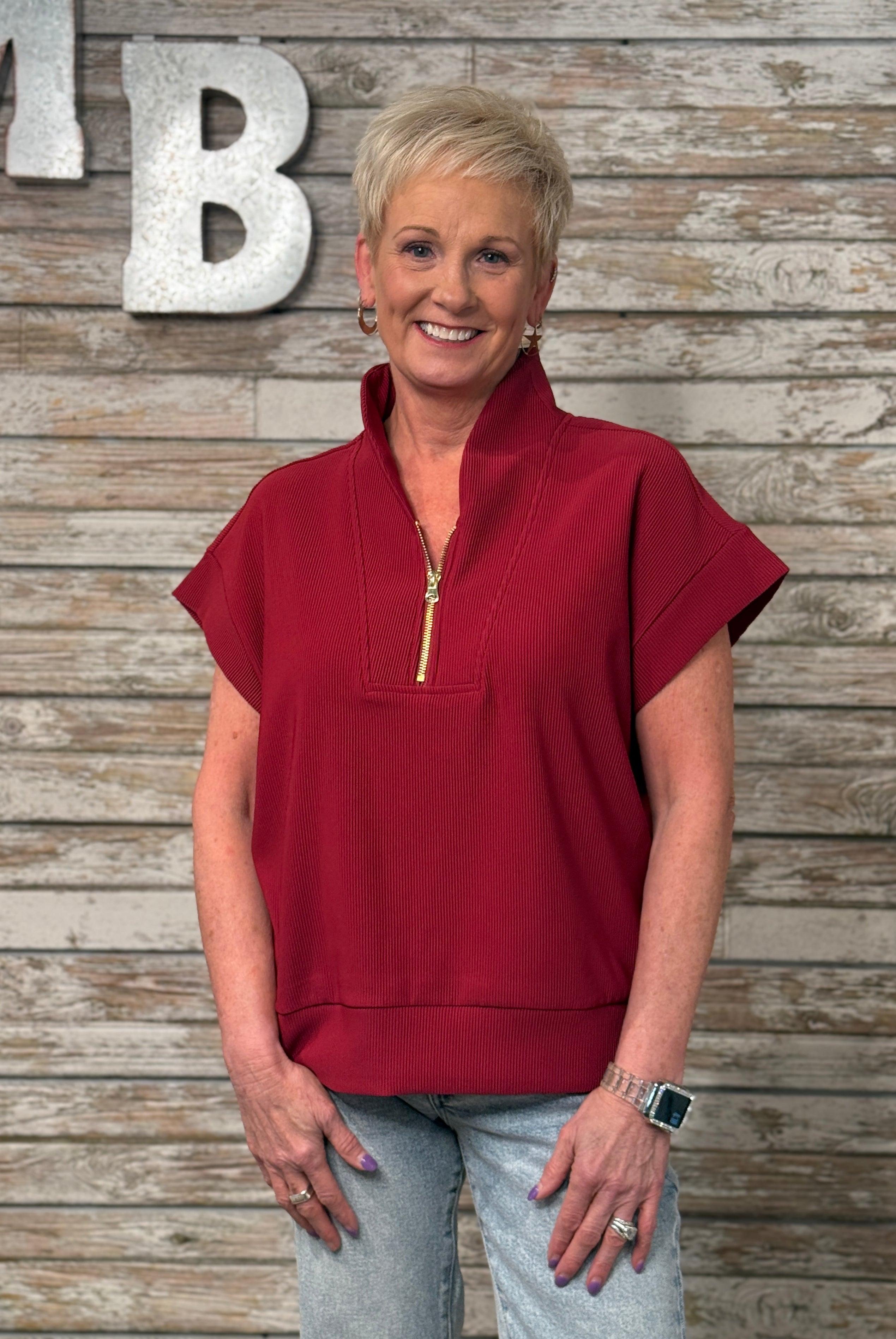 Woman wearing a red top with a wooden background