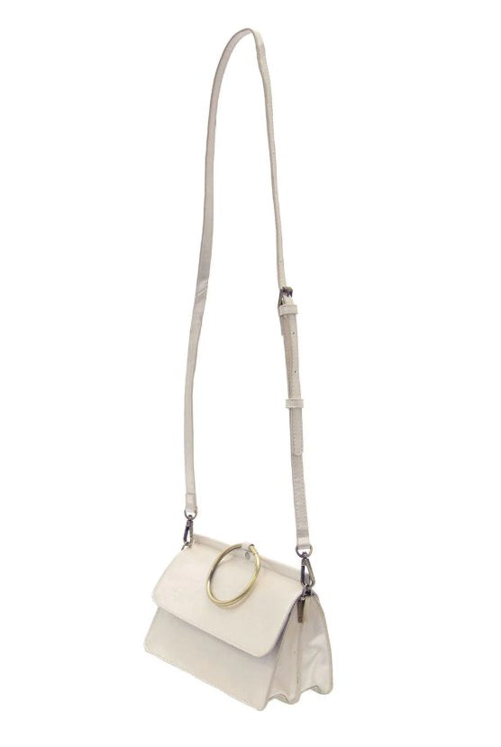 White handbag/crossbody with a gold ring handle on a white background