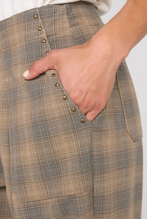 Close-up of plaid pants with a hand in the pocket on a white background