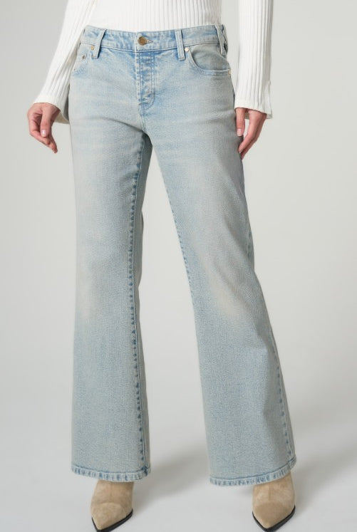 Light blue jeans worn by a person on a plain background