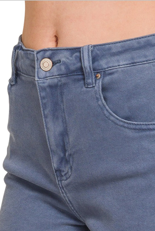 Close-up of blue jeans with a button and zipper on a white background