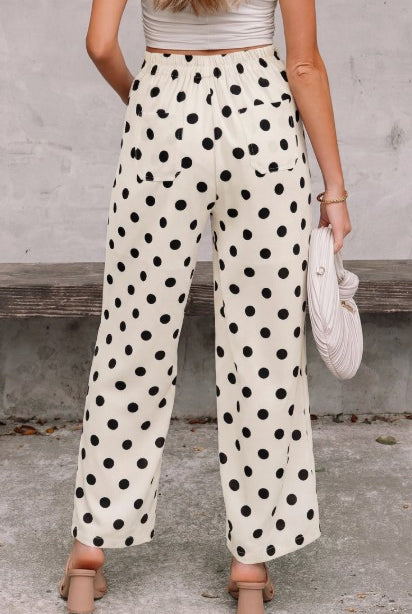 Person wearing polka dot pants with a neutral background