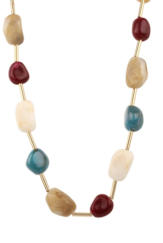 A gold-tone beaded necklace featuring alternating smooth, polished stone beads in cream, tan, deep red, teal blue, and light blue, displayed on a clean white background.