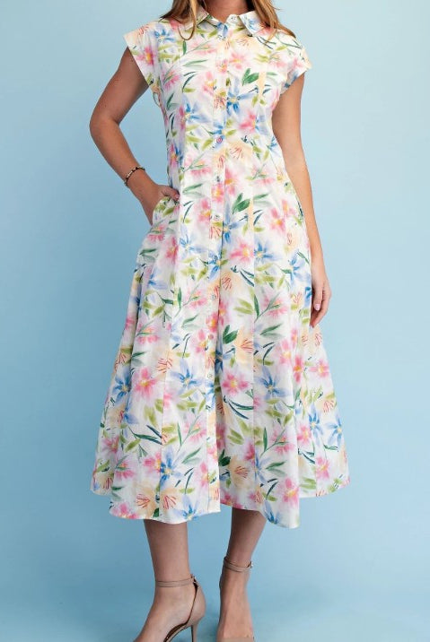Woman wearing a sleeveless floral midi dress with a button-front design, collared neckline, soft watercolor floral print, fitted waist, and flowy A-line silhouette.