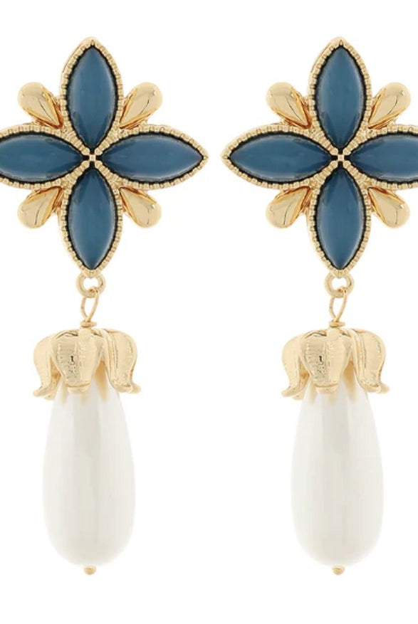 Earrings with blue flower-like tops and white teardrop-shaped bottoms on a white background