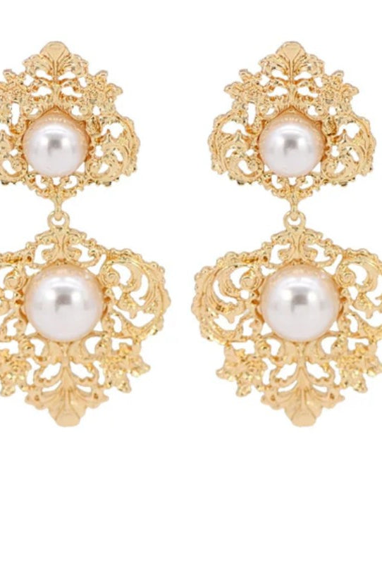 Gold earrings with pearl drops on a white background