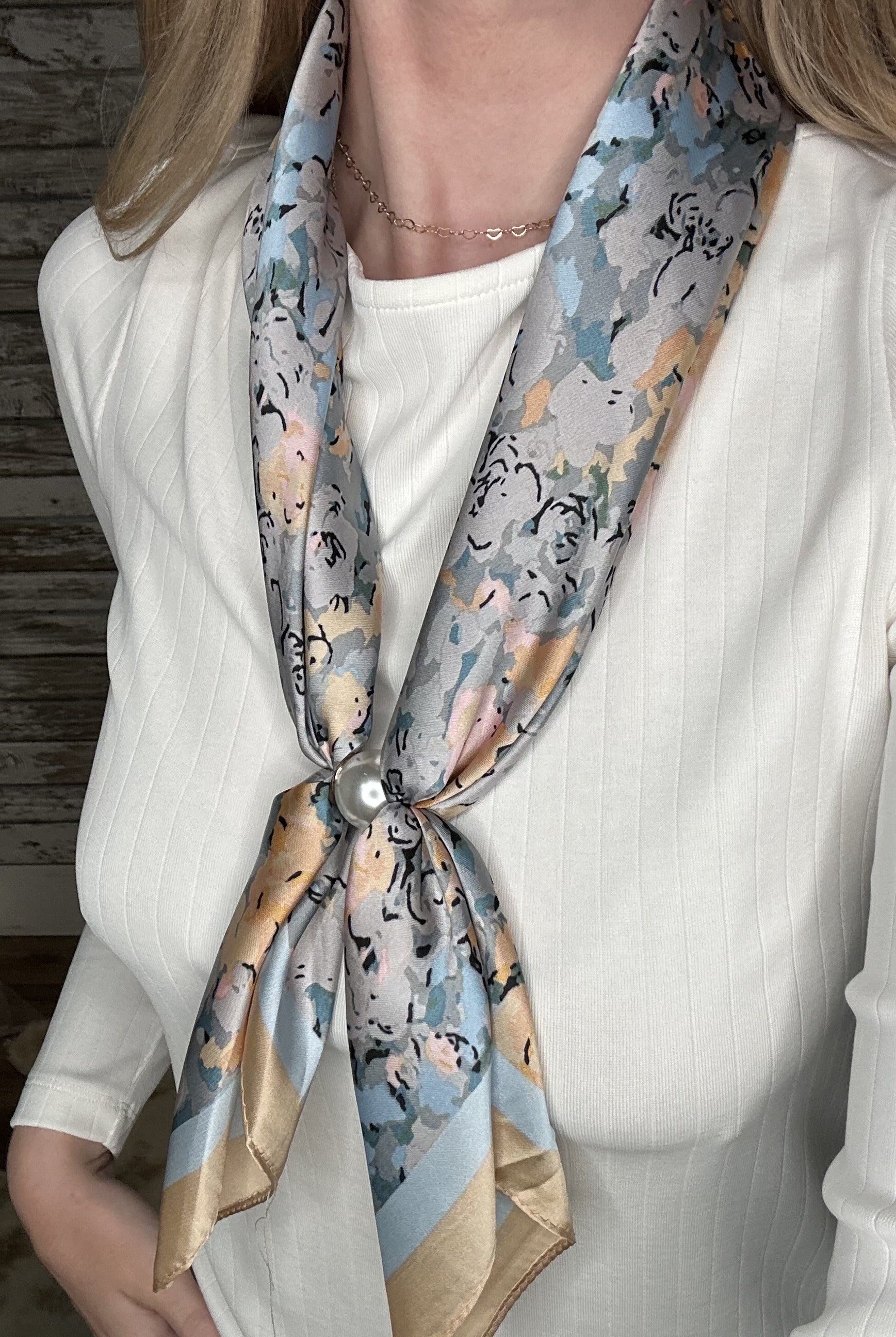 Silky pastel floral pearl magnetic scarf featuring soft blue, gray, and blush tones with a pearl clasp accent.