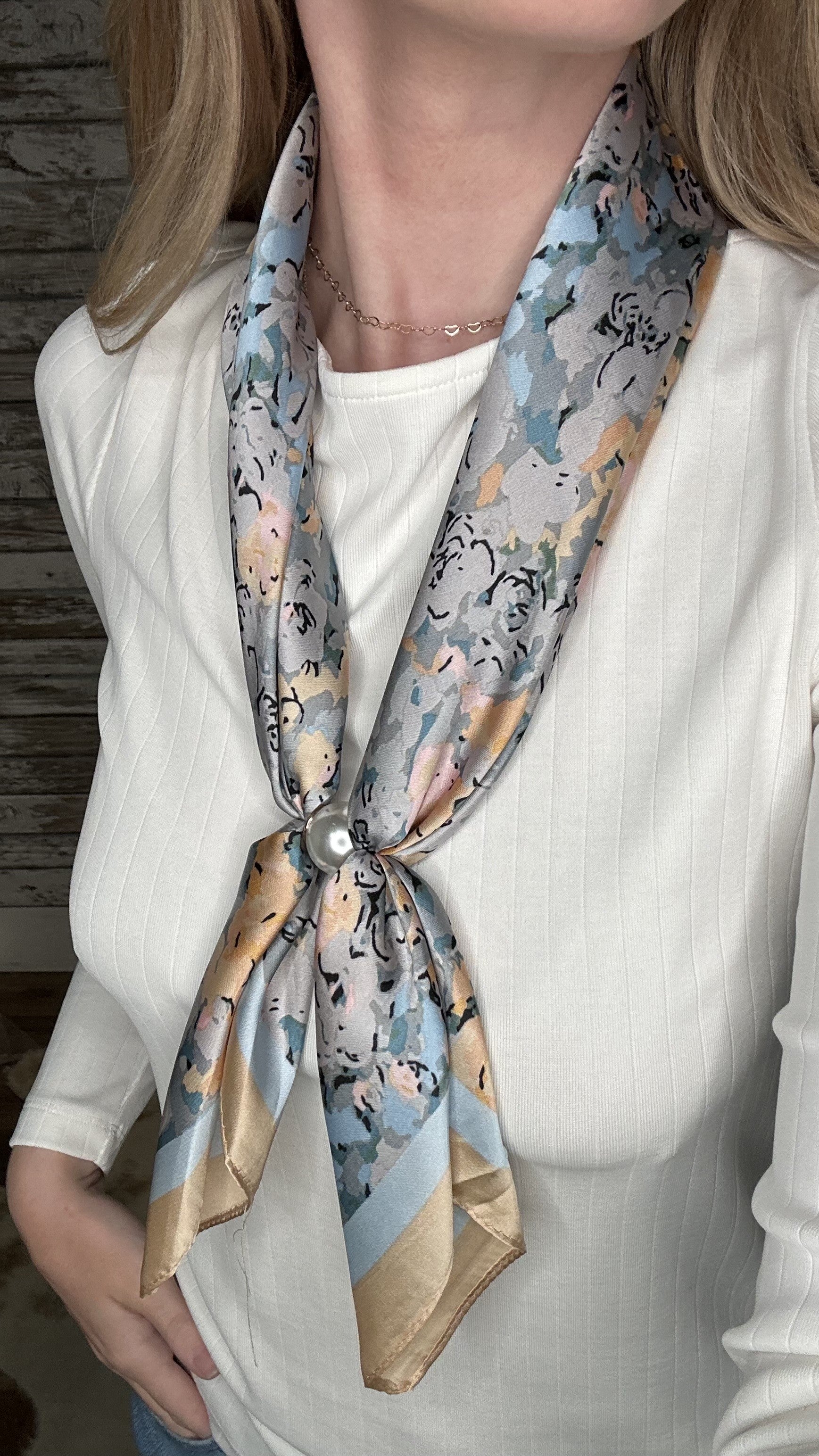 Silky pastel floral pearl magnetic scarf featuring soft blue, gray, and blush tones with a pearl clasp accent.
