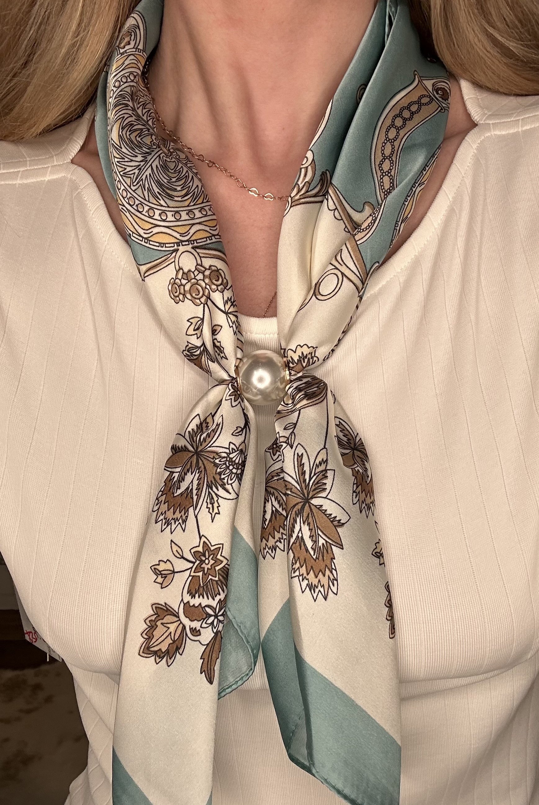 Silky teal and cream pearl magnetic scarf featuring ornate botanical prints with a satin finish and pearl clasp accent.