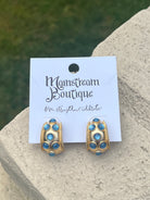 Gold and blue earrings against a stone background