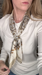 Silky floral pearl magnetic scarf in neutral tones featuring an ornate botanical print and elegant pearl clasp detail.