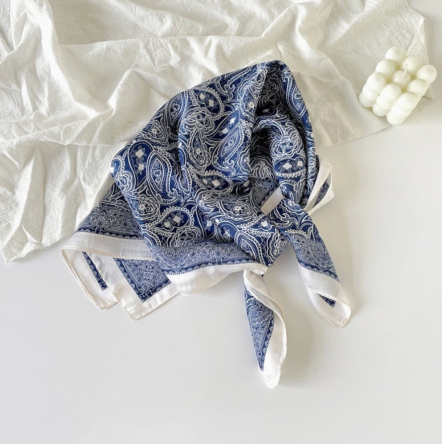 Blue paisley patterned scarf on a white surface