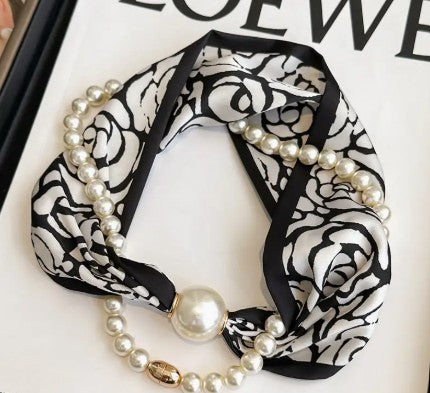 Black and white patterned headband with pearls on a white background