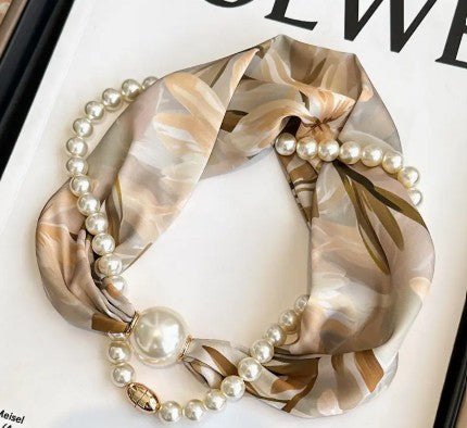 Decorative candle with pearls and gold ribbon on a white background
