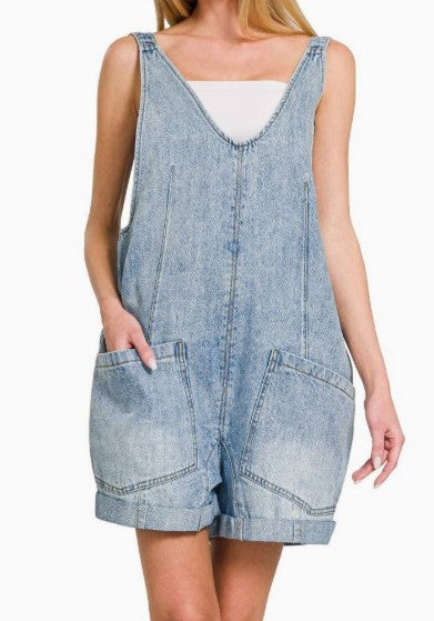 Denim overall dress worn by a person on a white background
