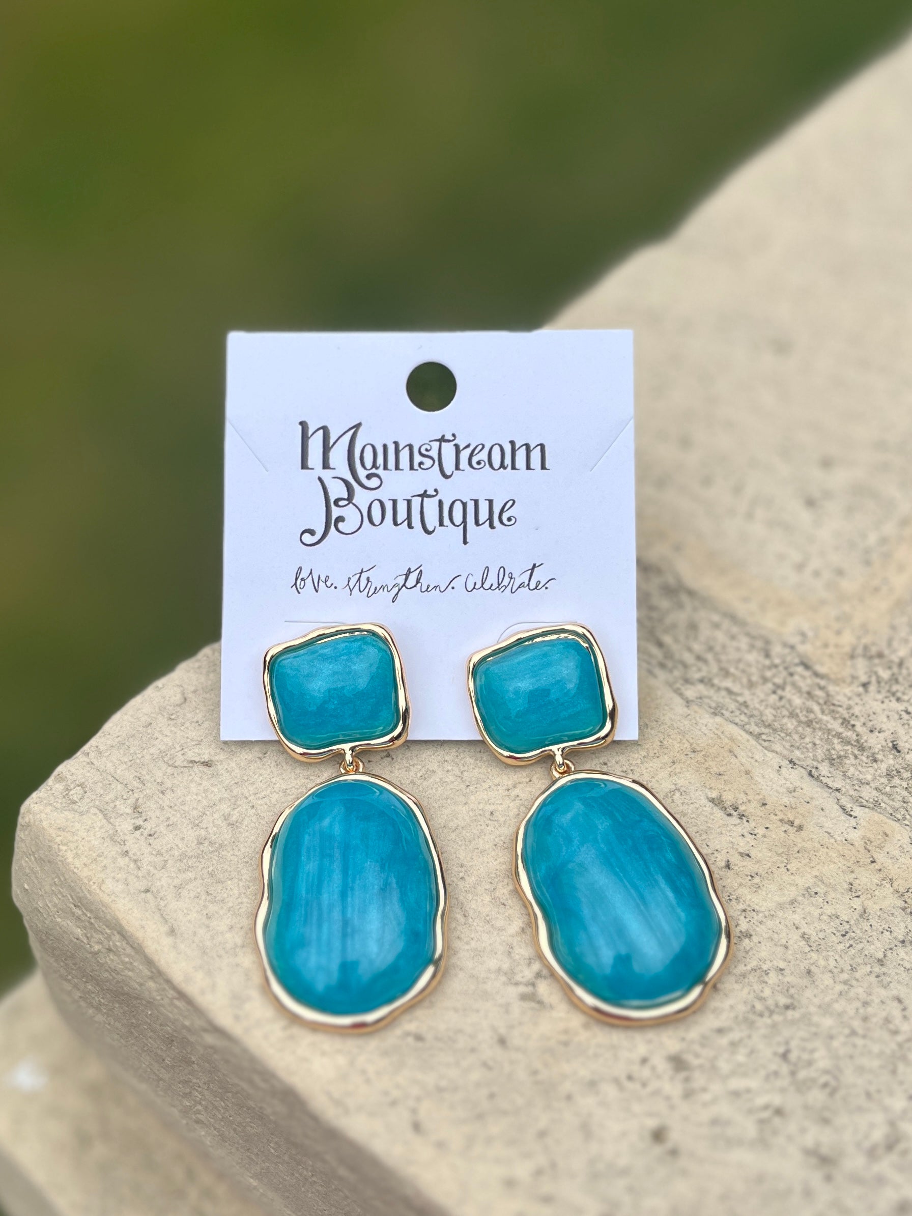 Turquoise earrings on against a blurred natural background