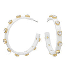 White hoop earrings with gold accents and clear stones on a white background