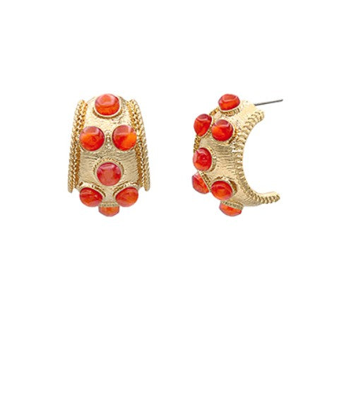 Gold hoop earrings with red gemstones on a white background