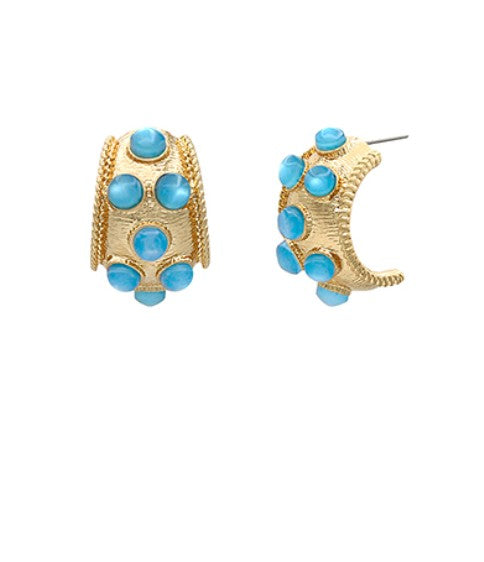 Gold hoop earrings with blue gemstones on a white background