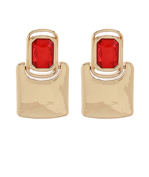 Gold earrings with red gemstones on a white background