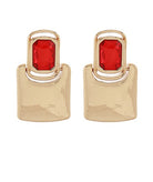 Gold earrings with red gemstones on a white background