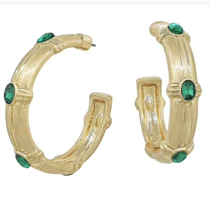 Gold hoop earrings with green gemstones on a white background