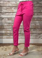 Person wearing bright pink pants with a wooden background