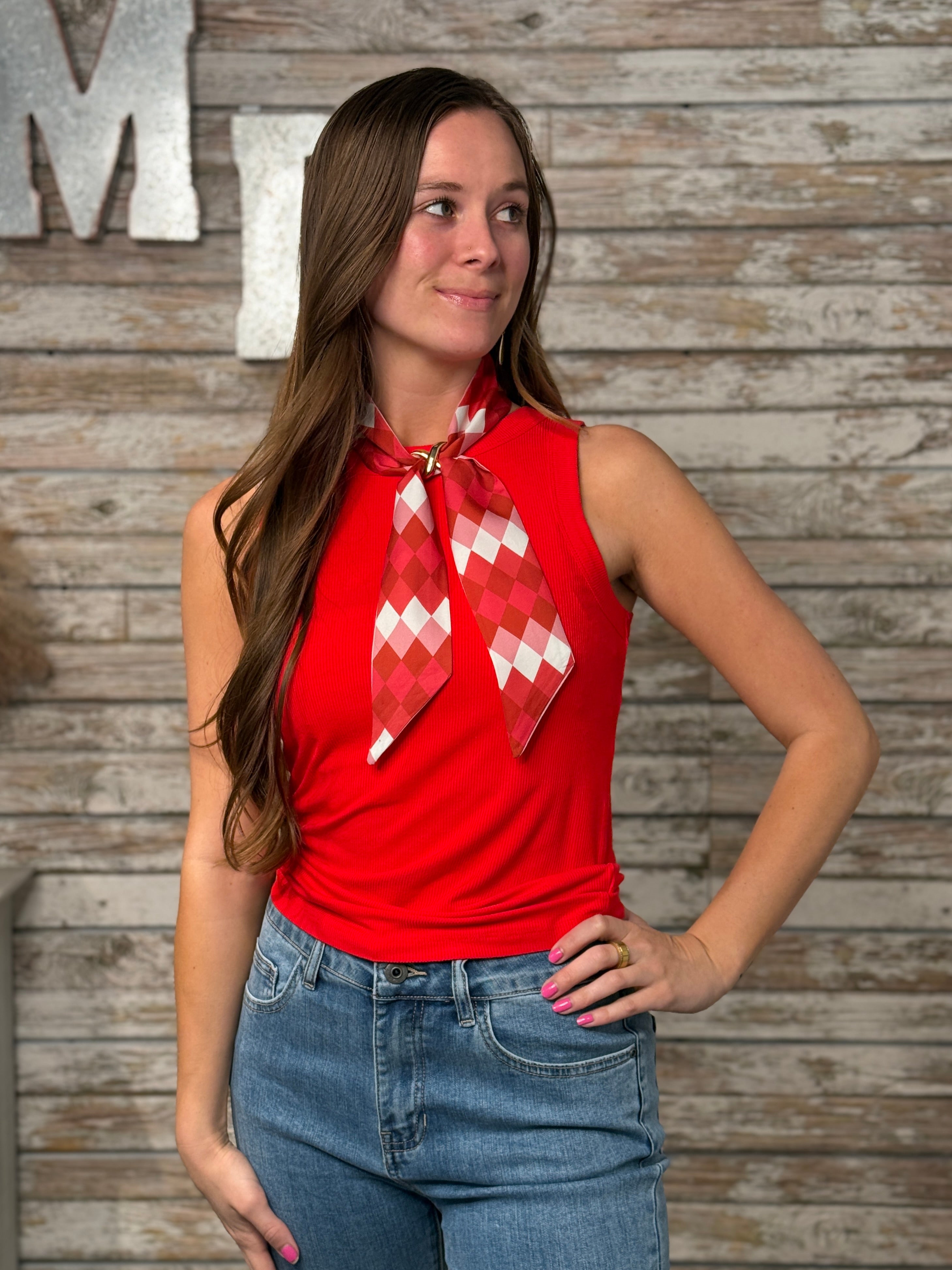 Woman wearing a fitted red ribbed sleeveless tank top with a high neckline and soft stretch fabric.