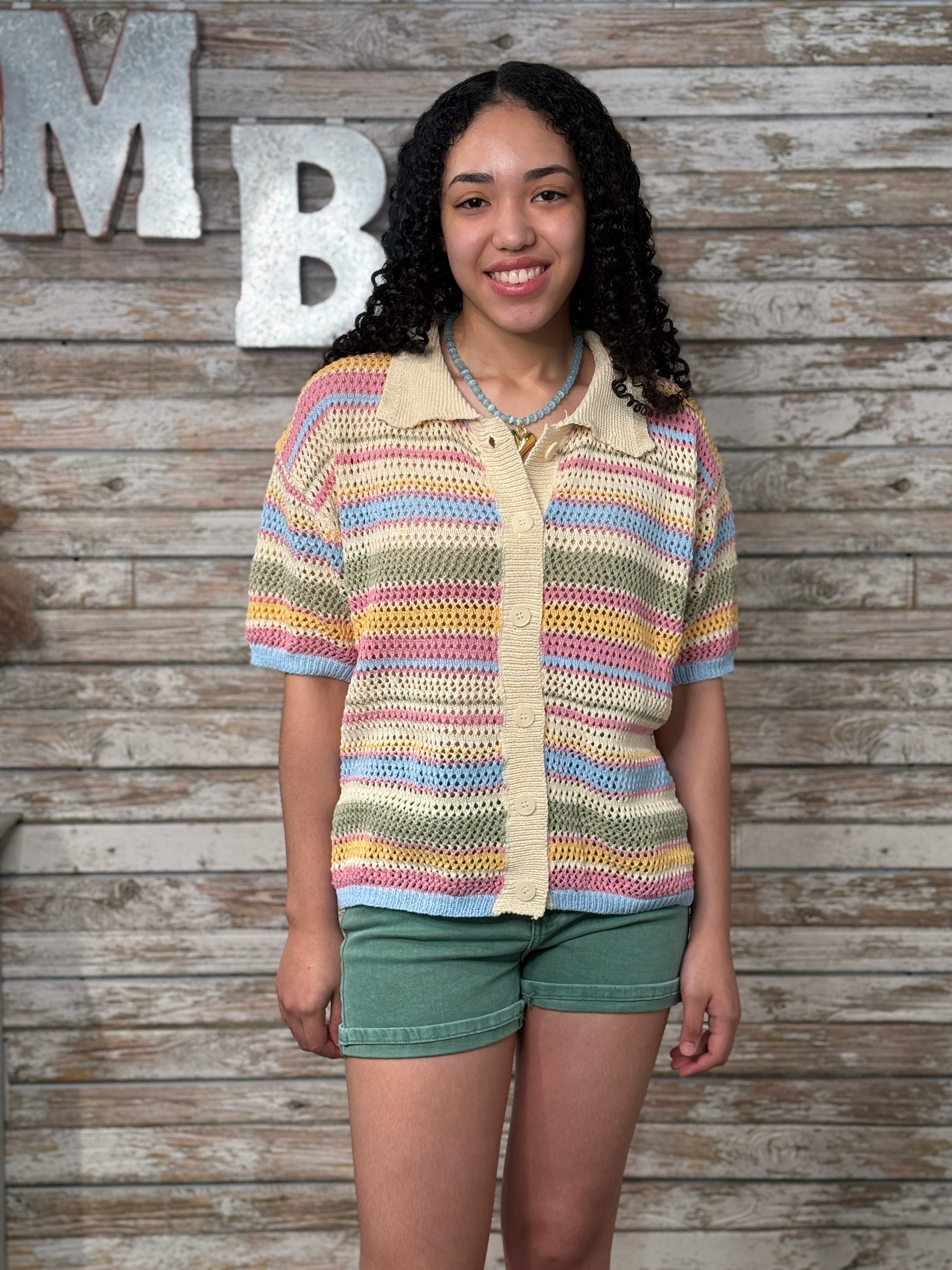 Woman wearing a colorful striped shirt against a wooden background