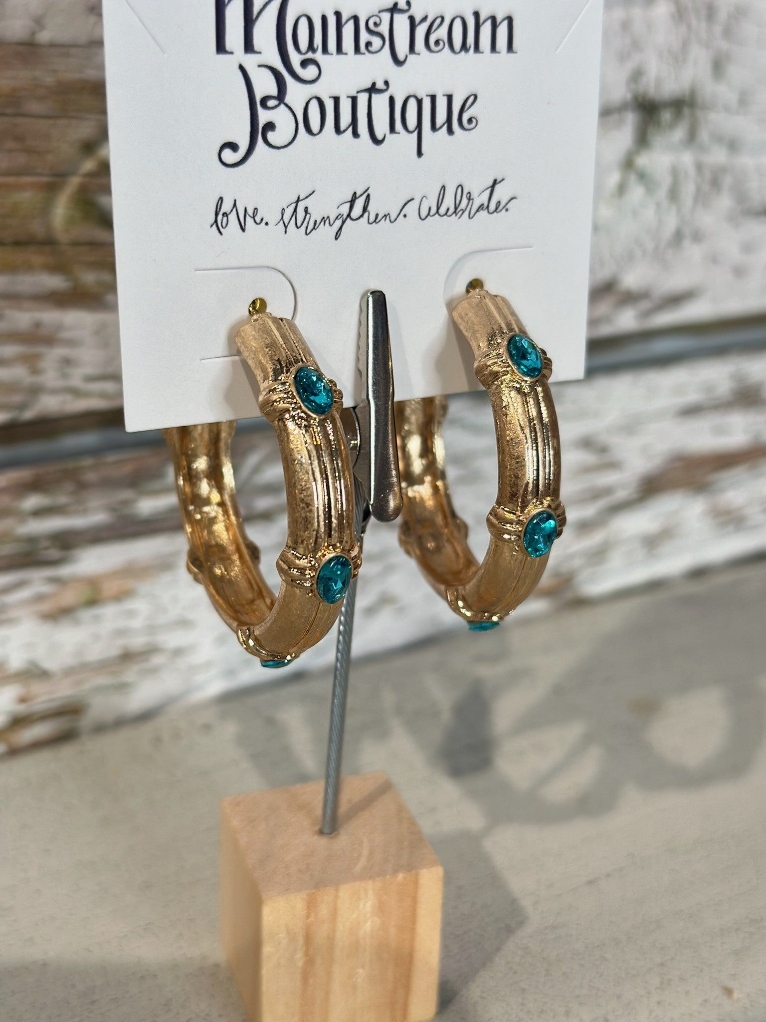 Gold hoop earrings with Aqua stones on a display card at Mainstream Boutique.