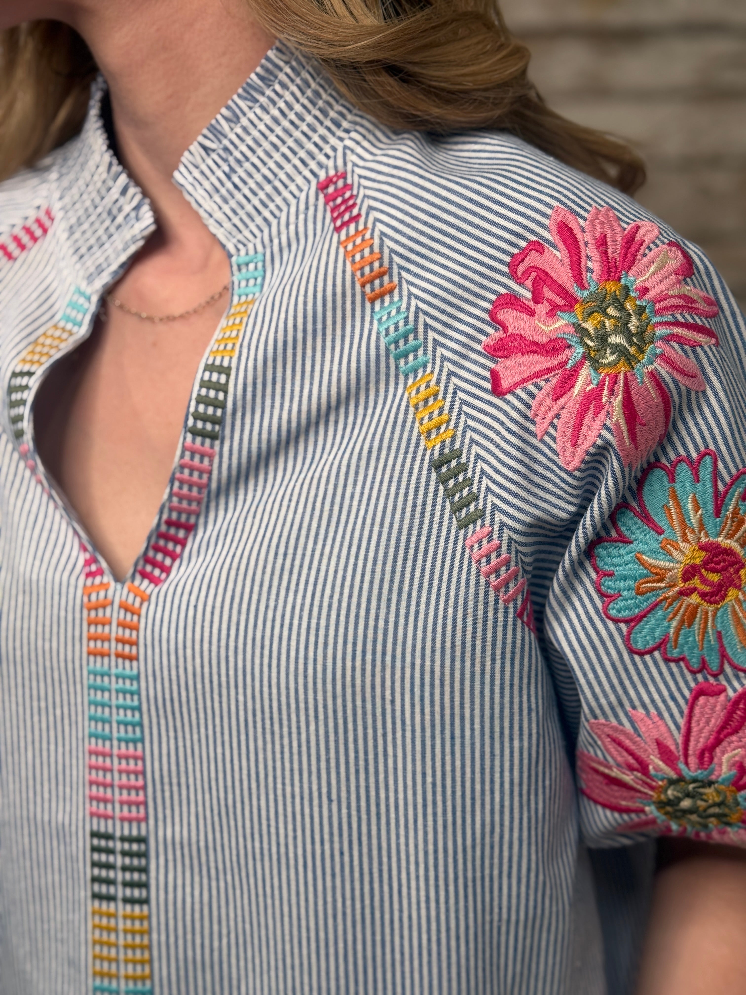 Close-up of a shirt with floral embroidery and colorful patterns.